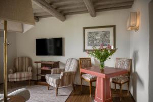 a living room with a table and chairs and a tv at Il Borro Relais & Châteaux in San Giustino Valdarno