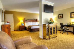 ClemmonsにあるVillage Inn Clemmons-Winston Salem, Trademark by Wyndhamのベッドとデスクが備わるホテルルームです。