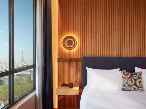 a bedroom with a bed and a large window at SO/ Paris Hotel in Paris