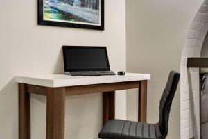 a laptop computer sitting on a desk with a chair at Wingate by Wyndham Williamsburg in Williamsburg