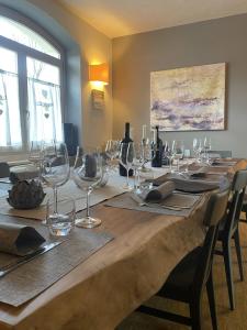 a long wooden table with wine glasses on it at Hotel Saisera in Valbruna