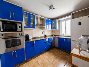a blue kitchen with stainless steel appliances and blue cabinets at Casa Mela in La Oliva