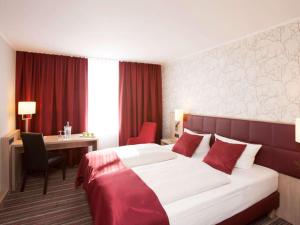 a hotel room with a bed and a desk at Fora Hotel Hannover by Mercure in Hannover