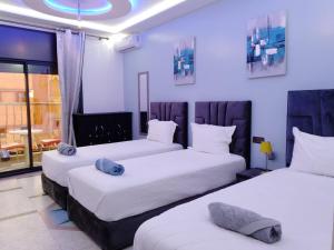 Duas camas num quarto com paredes brancas em DIAAFATE TANNIRTE em Khenifra