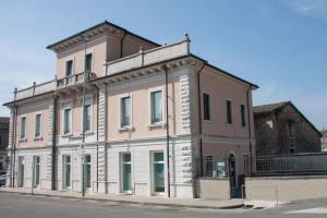 a large pink building on the corner of a street at Palazzo di Primavera Guest House in Caprino Veronese