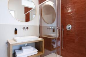 a bathroom with a shower and a sink and a mirror at ELECTRIC Rooms & Suites in Trento