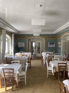 un comedor con mesas y sillas blancas en Hotel Saisera, en Valbruna