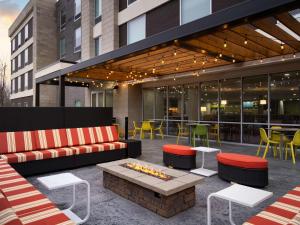 a patio with a couch and tables and chairs at Home2 Suites By Hilton Brownsburg in Brownsburg