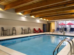 a pool in a hotel with chairs and tables at Home2 Suites By Hilton Brownsburg in Brownsburg