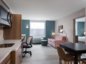 een kleine hotelkamer met een woonkamer en een slaapkamer bij Home2 Suites By Hilton Brownsburg in Brownsburg