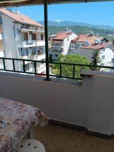 a balcony with a bed and a view of a city at Apartment Friends in Sandanski