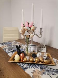un vassoio con uova di Pasqua e un vaso con fiori di Apartament Eagle a Predeal