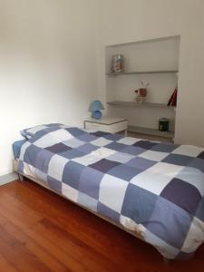 a blue and white bed in a room with a wooden floor at CENT UN... 