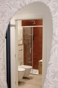 een badkamer met een douche, een toilet en een wastafel bij Electric Rooms & Suites in Trento