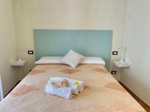 a bedroom with a bed with a doll on it at Domu Su Neulaghe in Villasimius +14 photos
