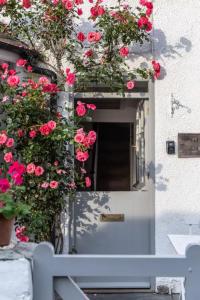 a white door with red roses growing around it at Geranium Cottage in Port Isaac