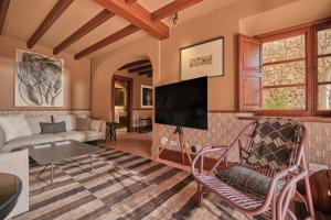 a living room with a tv and a couch at Valldemossa Hotel in Valldemossa