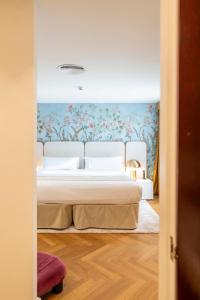 ein Schlafzimmer mit einem Bett und einer Wand mit Blumen in der Unterkunft Palacio Ca Sa Galesa in Palma de Mallorca