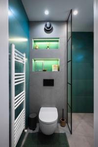 a bathroom with a toilet and a green wall at Exclusive One-Bedroom Retreat in Sofia