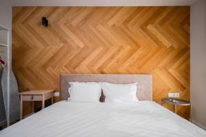 a bedroom with a white bed with a wooden wall at Exclusive One-Bedroom Retreat in Sofia