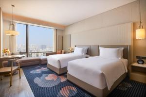 西安市にあるInterContinental Xi'an Hi-Tech Zoneのベッド2台とリビングルームが備わるホテルルームです。