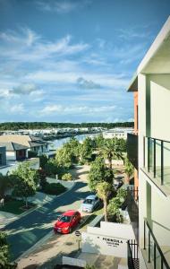 una macchina rossa parcheggiata in un parcheggio vicino a una strada di The Residences at The Peninsula a Gold Coast