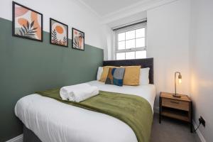 ein Schlafzimmer mit einem großen Bett und einer grünen Decke in der Unterkunft Stunning Two Bedroom Brighton Penthouse in Brighton & Hove