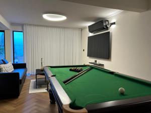 a living room with a pool table and a tv at מבית תכלת בית של חופש Allentown 21 אלנטאון 21 in Tiberias