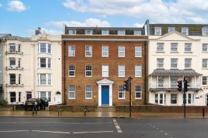 ein großes Backsteingebäude mit blauer Tür auf einer Straße in der Unterkunft Stunning Two Bedroom Brighton Penthouse in Brighton & Hove