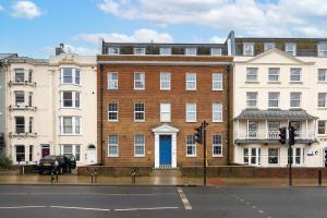 a large brick building with a blue door on a street at Stunning Two Bedroom Brighton Penthouse in Brighton & Hove