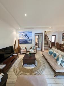 a living room with couches and a table at Waterfront Maison by Simply-Seychelles in Eden Island