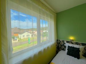 a bedroom with a window and a bed with a view at Hotel Le Ronchamp in Ronchamp