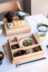 einen Tisch mit Teller mit Lebensmitteln und Schalen mit Reis in der Unterkunft The Tower Hotel Nagoya in Nagoya