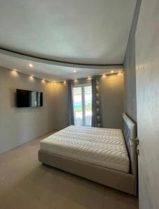 a bedroom with a bed and a flat screen tv at Villa Messina in Capoliveri