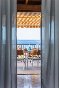 Casa Norma في ليباري: طاولة وكراسي على شرفة مع المحيط