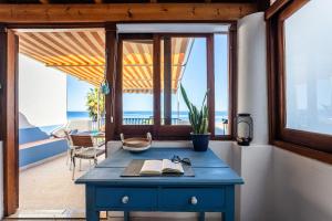 a blue desk in a room with a view of the ocean at Casa Norma in Lipari