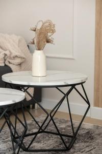 Una mesa blanca con un jarrón encima. en Modern Studio with Garden in Świnoujście by Noclegi Renters, en Świnoujście 13 fotos más