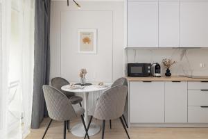 Una cocina con una mesa y sillas en una cocina. en Modern Studio with Garden in Świnoujście by Noclegi Renters, en Świnoujście