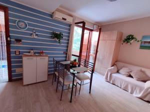 ein Wohnzimmer mit einem Tisch und ein Zimmer mit einem Sofa in der Unterkunft Grazioso monolocale in Sardegna in Marina di Sorso
