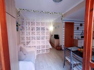 ein Wohnzimmer mit einem weißen Vorhang in einem Zimmer in der Unterkunft Grazioso monolocale in Sardegna in Marina di Sorso