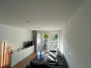 ein Wohnzimmer mit einem Sofa und einem großen Fenster in der Unterkunft The Livingroom Apartment Cologne in Köln