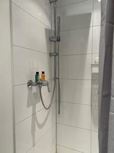 eine Dusche im Bad mit weißen Fliesen in der Unterkunft The Livingroom Apartment Cologne in Köln