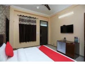 a bedroom with a bed with a television and a desk at Bharti Hotel Uhdampur in Udhampur