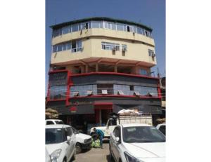a building with cars parked in front of it at Bharti Hotel Uhdampur in Udhampur