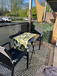 einen Tisch und Stühle auf einem Balkon mit einem Tisch in der Unterkunft The Livingroom Apartment Cologne in Köln