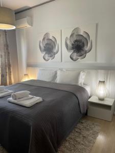 1 dormitorio con 1 cama con 2 flores en la pared en Urban Residence, en Atenas