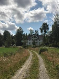 eine unbefestigte Straße vor einem weißen Haus in der Unterkunft Magnor House in Eidskog, Hedmark close to The Plus and Magnor Glassverk in Magnor
