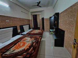 a hotel room with two beds and a tv at AASHIRWAD HOTEL in Katra