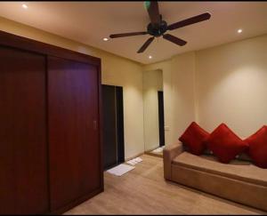 salon z wentylatorem sufitowym i kanapą w obiekcie The Grand Legacy Resort & Spa - TGL - Pure Vegetarian Mahabaleshwar w mieście Mahabaleshwar