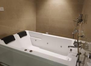 y baño con bañera blanca. en The Grand Legacy Resort & Spa - TGL - Pure Vegetarian Mahabaleshwar, en Mahabaleshwar
